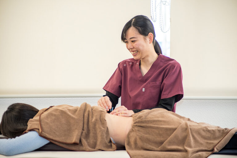 施術を行う接骨院のスタッフと患者の腰のケア