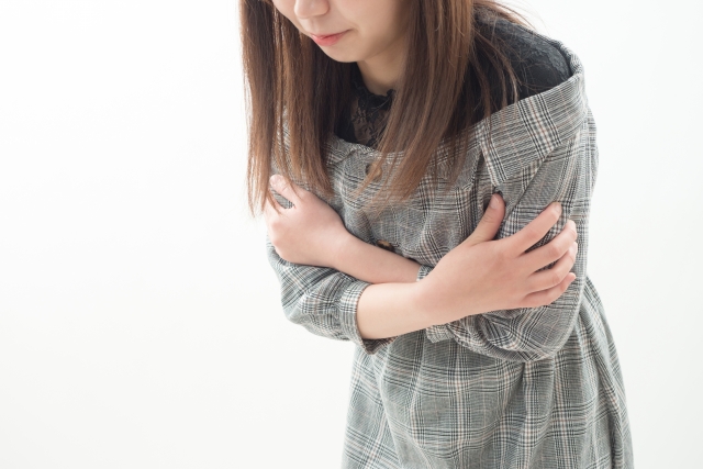 冷えによる血流低下で肩が痛む女性のイメージ