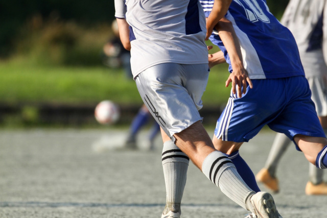 サッカーをする選手の脚の動き、スポーツ障害治療と接骨院の連携を連想させる場面