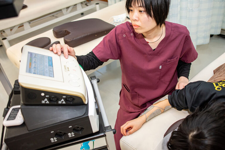 ハイボルテージで腰痛治療する接骨院の施術風景